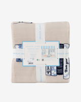 A folded beige decorative throw blanket with blue and white striped and knit patterns, wrapped in a white paper band labeled 'DRAPER JAMES' with its retail tag in the center, on a plain white background.