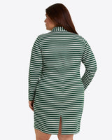 A woman shown from behind wears the Draper James Elsie Turtleneck Dress in Green Stripe, a long-sleeve cotton jersey dress with green and white stripes and a small back slit.