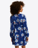 A person with curly hair wears the Draper James Kellie Babydoll Dress in Printed Dot Jacquard, shown from the back against a plain white background.