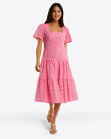 A woman elegantly wears the Draper James Caitlyn Midi Dress in Eyelet, featuring a square neckline, against a white background, complemented by her sandals.