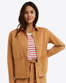 A person wearing the Draper James Utility Jacket in Cotton Twill over a red and white striped shirt stands with one hand on their hip, smiling.