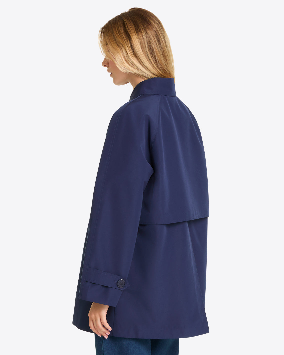 A person is seen from the back and side, wearing a Draper James Button Front Coat in navy blue with a high collar, buttoned cuffs, and classic loose-fit silhouette, set against a plain background.