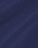 Close-up of a smooth, dark blue fabric with subtle diagonal shadows and soft texture, ideal for the classic silhouette of the Draper James Button Front Coat.