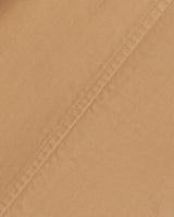 Close-up of beige stretch-cotton fabric with a diagonal seam, great for crafting Draper James' relaxed-fit Utility Pant in Cotton Twill.