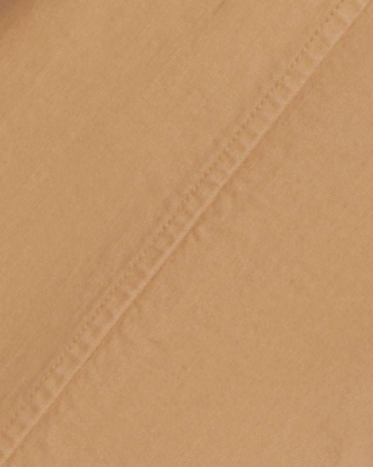 A close-up of tan stretch-cotton twill from Draper James shows visible stitching and texture, perfect for crafting a stylish Utility Jacket in Cotton Twill or an ideal lightweight spring layer.