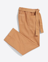 The Draper James Utility Pant in Cotton Twill, featuring a relaxed fit, high waist, front pockets, and a fabric tie belt in tan, is laid flat on a white background.