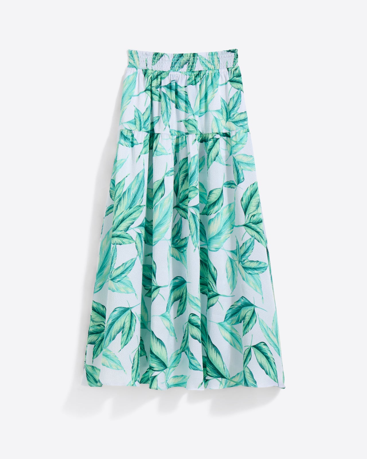 The Draper James Midi Skirt in Hammered Satin is a light blue, green leaf-patterned midi with a smocked and elastic waistband, shown on a white background.