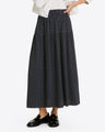 A person wearing the Draper James Midi Skirt in Polka Dot, paired with a white jacket and black loafers, stands against a plain background.