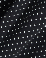 Close-up of the Draper James Midi Skirt in Polka Dot, featuring black fabric with evenly spaced white dots and subtle folds—ideal for a smocked waist or a flowing silhouette.