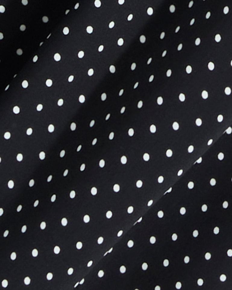 Close-up of the Draper James Midi Skirt in Polka Dot, featuring black fabric with evenly spaced white dots and subtle folds—ideal for a smocked waist or a flowing silhouette.