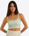 A woman with long dark hair wears the Draper James Smocked Bikini Topâ€”colorful, striped, with thin strapsâ€”paired with matching high-waisted bottoms against a plain light background. This seersucker set combines comfort and sunny-day style.