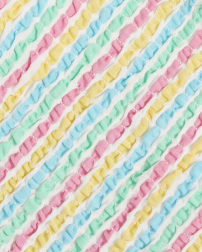 Close-up of the Draper James Smocked Bikini Top, featuring textured fabric with diagonal pastel pink, blue, green, and yellow stripes on white. Its soft, quilted surface adds playful charm to this vibrant swimwear piece.