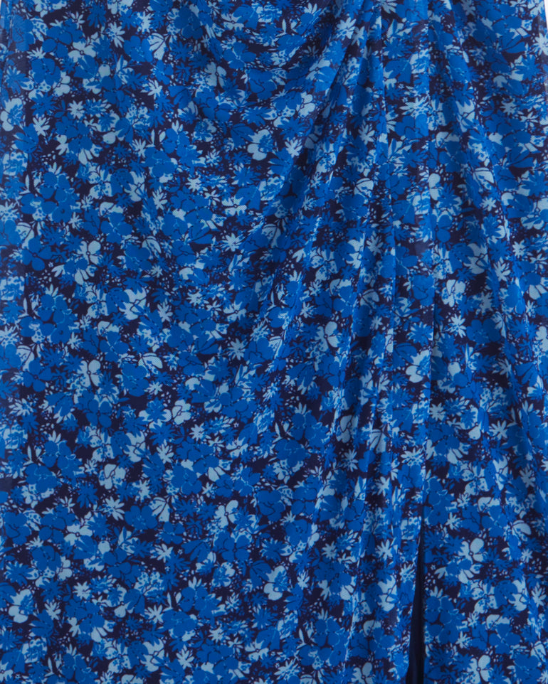 Close-up of the Selena V-Neck Midi Dress by Draper James, featuring blue stretch mesh with a dense scattered ditsy floral print and gathered draping.
