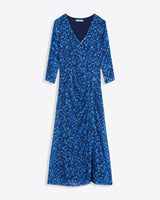 The Selena V-Neck Midi Dress in Blue Scattered Ditsy by Draper James features three-quarter sleeves and a side slit, made from floral-printed stretch mesh and shown on a white background.