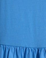 Close-up of the Draper James Lila Mixed Media Midi Dress in Light Blue, showcasing a ribbed cotton bodice and a gathered, ruffled skirt.