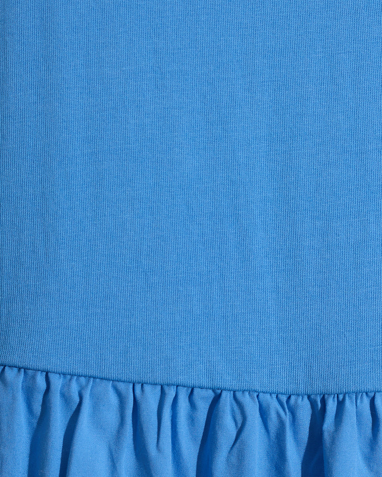 Close-up of the Draper James Lila Mixed Media Midi Dress in Light Blue, showcasing a ribbed cotton bodice and a gathered, ruffled skirt.