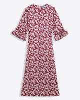 The Draper James Crewneck Midi Dress in hammered satin features a maroon and white floral pattern, ruffled cuffs, and a round neckline. Ankle-length with long sleeves. Machine wash cold for easy care.