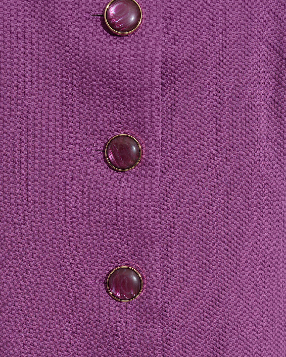 Close-up of the textured purple fabric from the Draper James Hannah Shift Dress in Amethyst, featuring three round purple buttons arranged vertically on its classic silhouette.