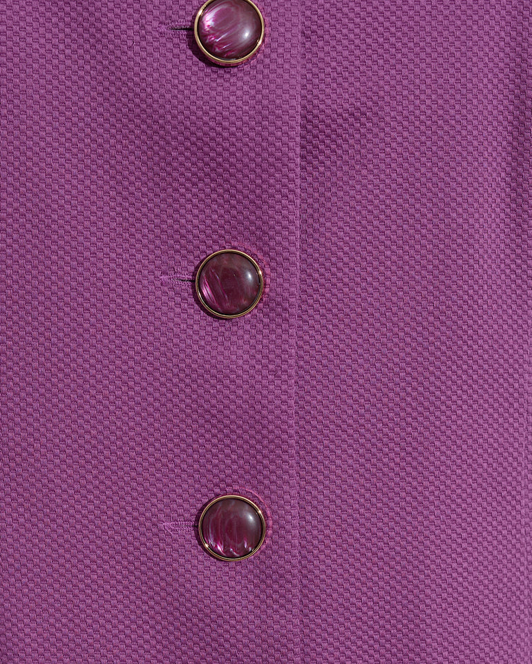 Close-up of the textured purple fabric from the Draper James Hannah Shift Dress in Amethyst, featuring three round purple buttons arranged vertically on its classic silhouette.