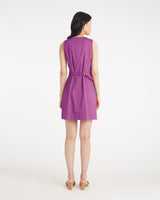 A woman stands facing away, wearing the Draper James Hannah Shift Dress in Amethyst with a belted waist and classic silhouette, paired with beige heels, against a plain white background.