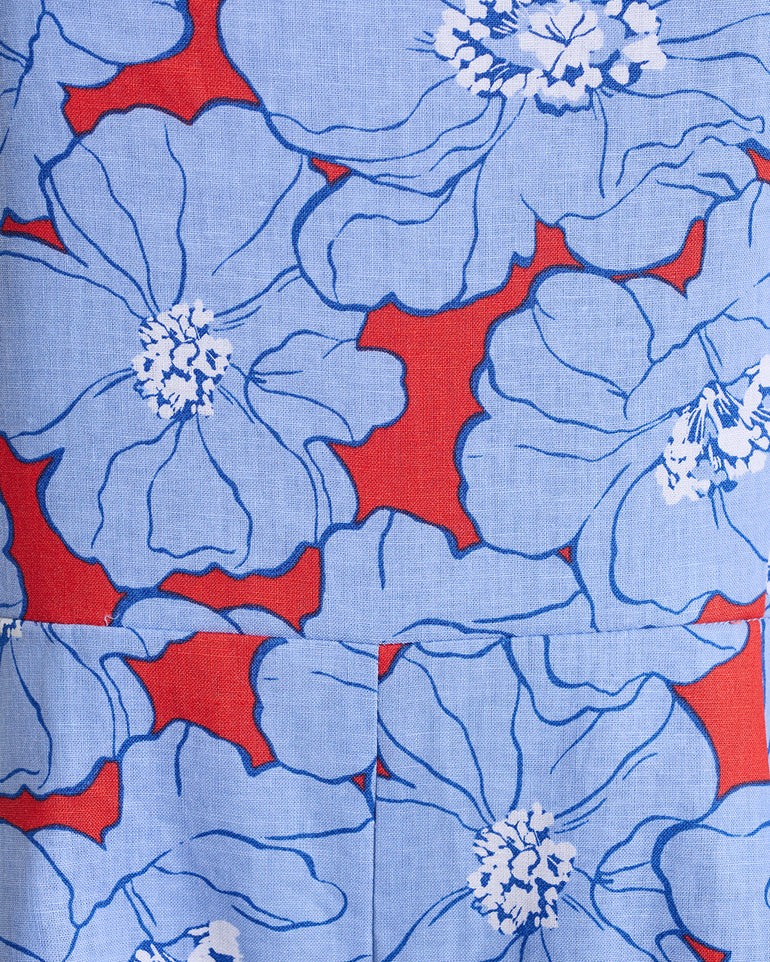 The Mae Love Circle Mini Dress in Floating Floral by Draper James features a blue fabric with large dark-blue-outlined flowers, white blooms, and red accentsâ€”plus an elegant two-way zipper for style and versatility.