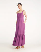A woman wears the Draper James Brynn Sleeveless Midi Dress in Amethyst, featuring a button-down front and ruffled hem, paired with beige sandals, set against a plain white background.