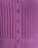 Close-up of the Draper James Brynn Sleeveless Midi Dress in Amethyst, a midi dress with vertical pleats and fabric-covered buttons down the front.