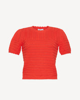 The Draper James Short Sleeve Pointelle Sweater features a round neckline, bright red hue, and textured openwork design, crafted from lightweight cotton for breathable comfort.