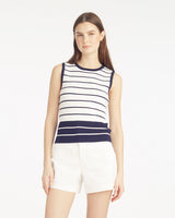 A woman faces forward against a white background, wearing the Draper James Sweater Tankâ€”a stylish striped polyester-blend topâ€”paired with white shorts.