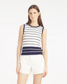 A woman faces forward against a white background, wearing the Draper James Sweater Tankâ€”a stylish striped polyester-blend topâ€”paired with white shorts.
