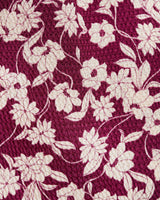 A close-up of the maroon Hammered Satin Crewneck Midi Dress by Draper James shows its textured surface with a cream floral pattern. This elegant polyester dress is easy to care forâ€”just machine wash cold.