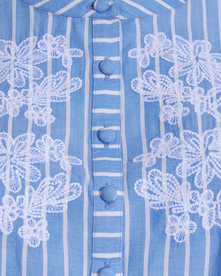 Close-up of the Puff Sleeve Top with Floral Embroidery by Draper James, showcasing blue and white stripes, delicate white floral embroidery, and fabric-covered buttonsâ€”a perfect summer top.
