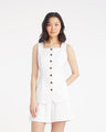 A woman wears the Draper James Tailored Top in Piqueâ€”a sleeveless, stretch cotton button-front styleâ€”with matching white shorts, standing against a plain white background.