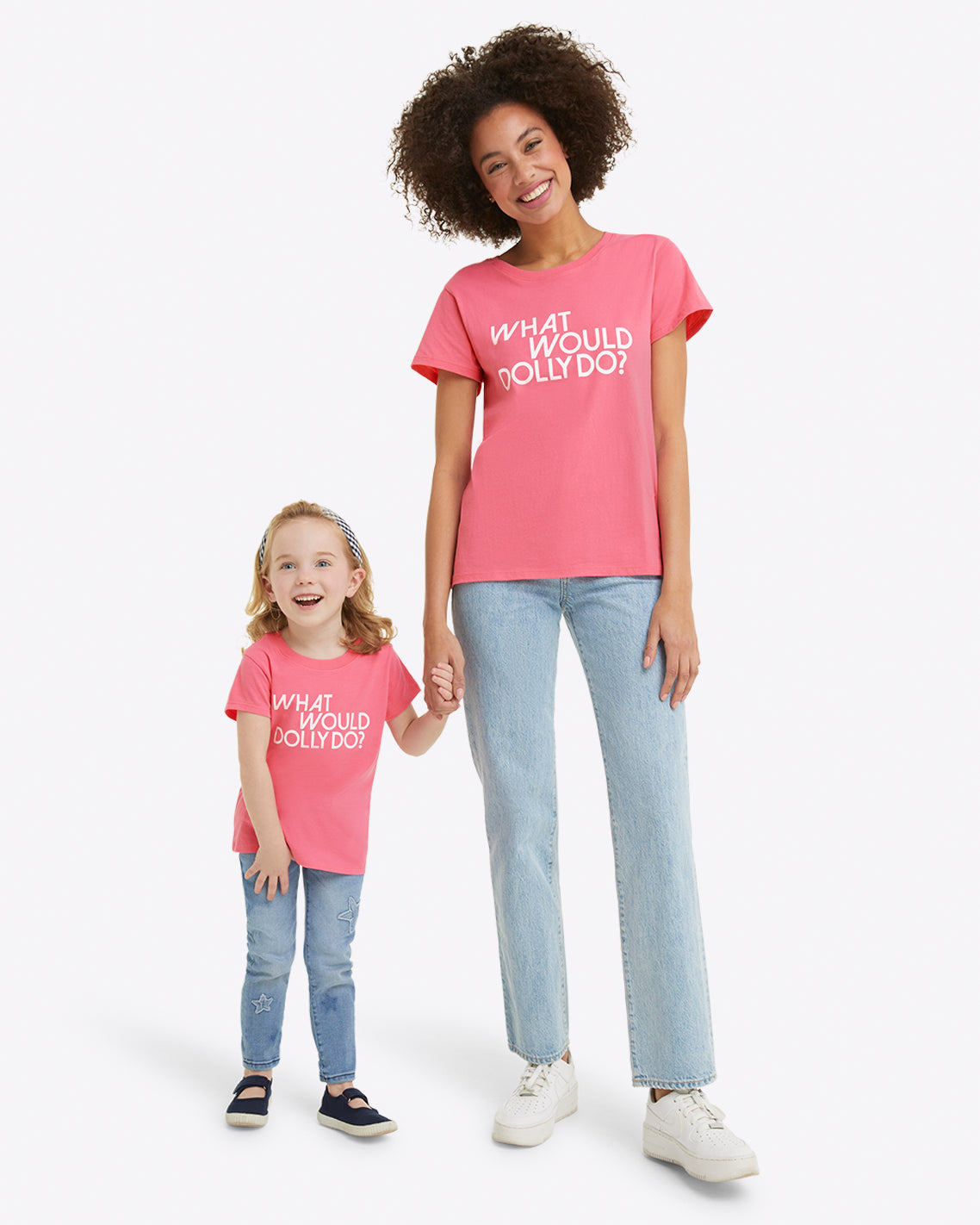 An adult and a child hold hands against a white background, sporting matching Draper James Kids WWDD Pink T-Shirts with "WHAT WOULD DOLLY DO?" on jersey cotton.